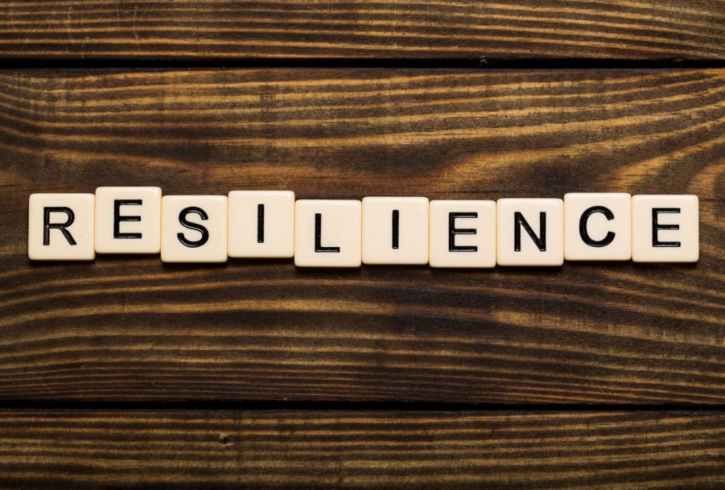 Stamina. Business man pointing to transparent board with text: Resilience